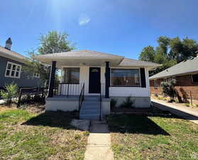 Bungalow-style house with covered porch, a front yard, and roof with shingles