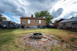 Rear view of house featuring a fire pit, and fenced in backyard