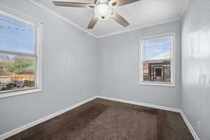 Bedroom with dark carpet, crown molding, and ceiling fan