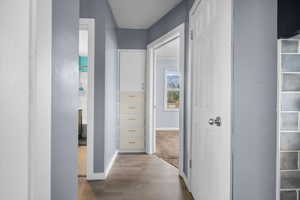 Corridor featuring baseboards and LVP flooring