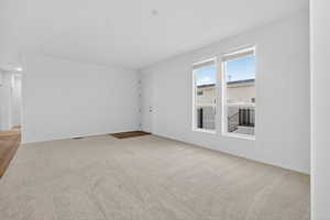 Spare room with light colored carpet and baseboards