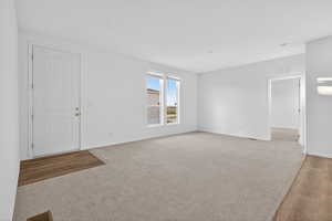 Spare room featuring light carpet and light wood-style floors