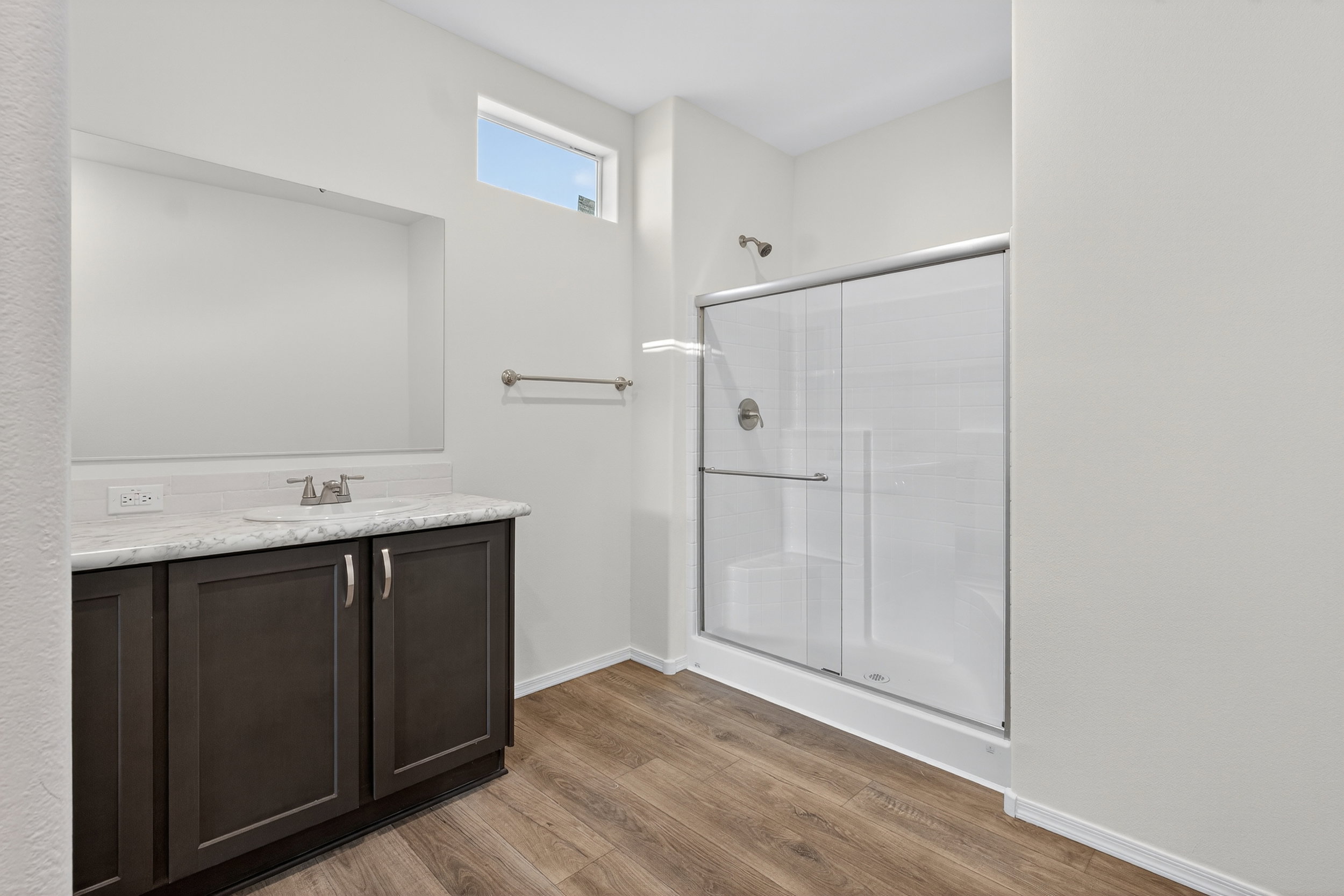 Bathroom featuring a shower stall, vanity, and light wood finished floors