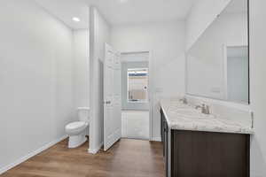 Bathroom with double vanity and dark wood-style floors