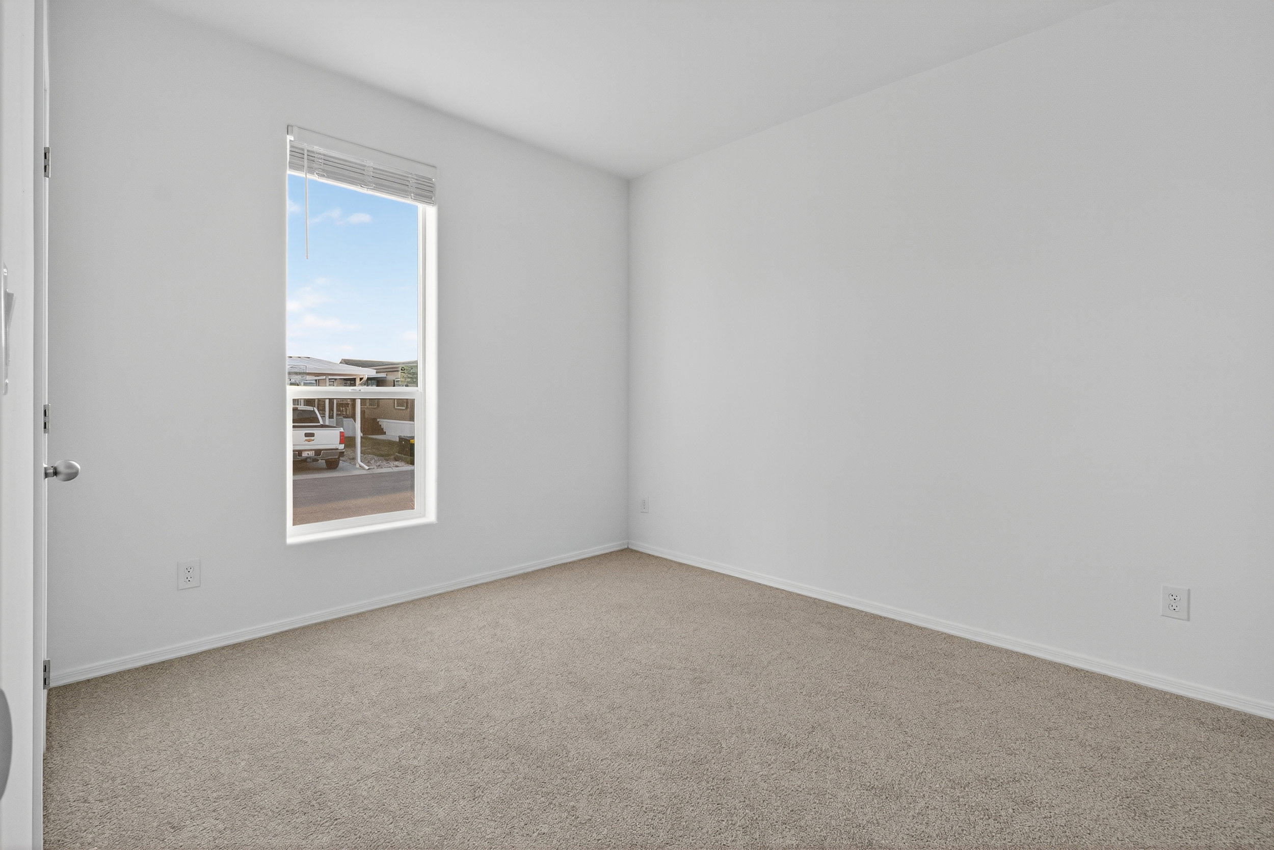 Spare room with light carpet and baseboards