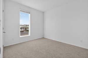 Spare room with light carpet and baseboards