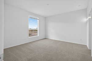 Unfurnished room with light carpet and baseboards