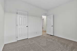 Unfurnished bedroom featuring carpet flooring and baseboards