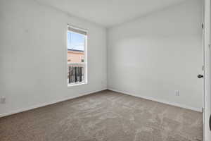 Carpeted empty room featuring baseboards