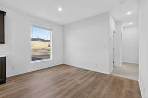 Unfurnished dining area with light wood finished floors and recessed lighting