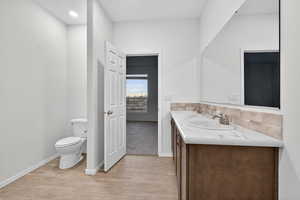 Full bathroom with double vanity and light wood-type flooring