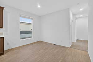 Unfurnished dining area featuring light wood-style flooring and recessed lighting
