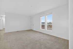 Unfurnished room featuring light carpet and baseboards