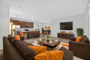 *Virtually staged* Living room with light wood-style floors and recessed lighting