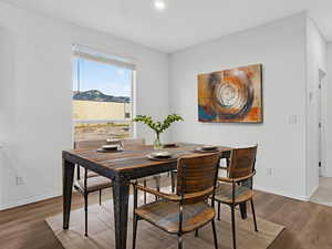 *Virtually staged* Dining area with wood finished floors and recessed lighting