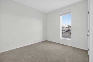 Spare room with carpet and baseboards