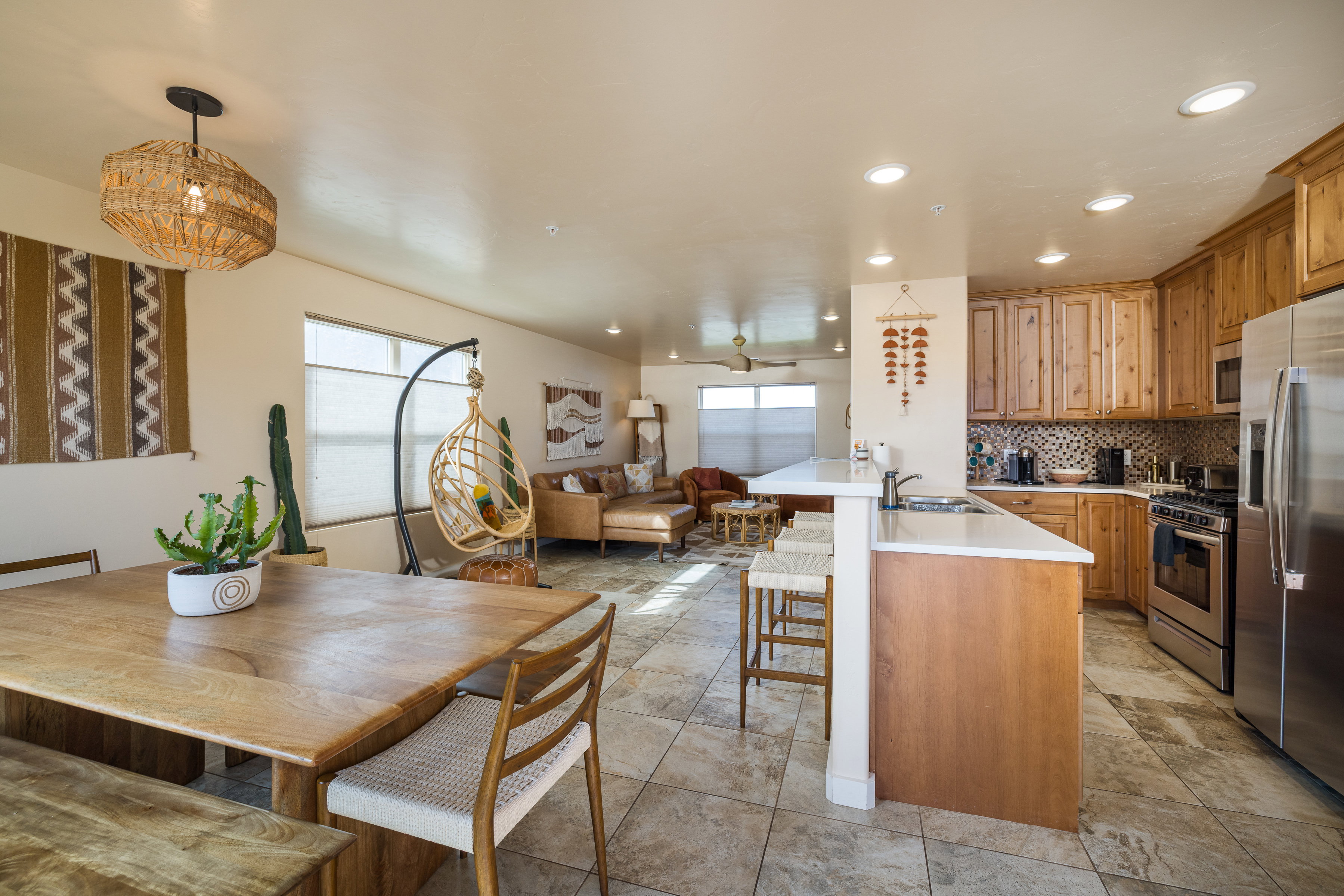 Kitchen with light countertops, decorative backsplash, open floor plan, a kitchen breakfast bar, and appliances with stainless steel finishes