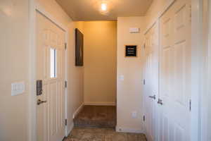 Hallway featuring tile patterned floors and carpet