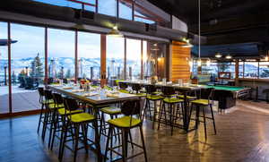 Dining space with a mountain view, plenty of natural light, dark wood finished floors, billiards, and a high ceiling