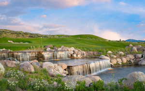 Water view with a mountainous background and a golf course