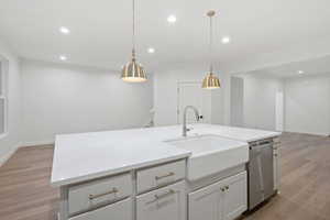 Kitchen with light wood-type flooring, recessed lighting, pendant lighting, white cabinetry, and stainless steel dishwasher