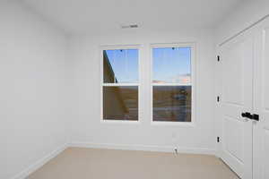 Empty room featuring carpet floors and baseboards