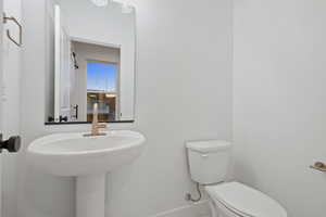 Half bath featuring toilet and baseboards