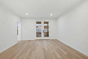 Unfurnished room featuring light wood-type flooring, recessed lighting, and french doors