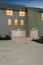View of front of home featuring stucco siding, driveway, a garage, and roof with shingles