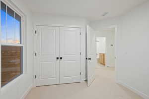 Hall with light colored carpet and baseboards