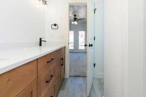 Bathroom featuring double vanity, light wood-style flooring, and light colored carpet