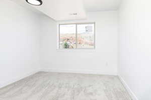 Unfurnished room featuring light colored carpet and baseboards