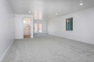 Unfurnished bedroom featuring light colored carpet, recessed lighting, and connected bathroom