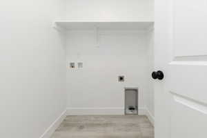Laundry area with hookup for a washing machine, hookup for an electric dryer, and light wood-type flooring