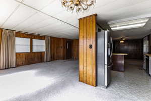 Empty room with wooden walls, light floors, and ceiling fan