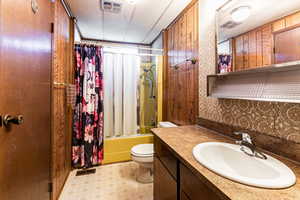 Full bath with shower / bath combination with glass door, vanity, and light flooring