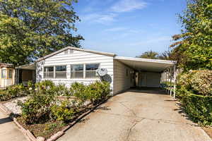 Manufactured / mobile home featuring driveway and an attached carport