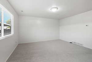Carpeted spare room with baseboards and a textured ceiling