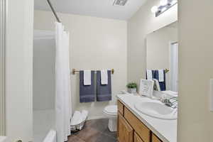 Bathroom featuring vanity, dark tile patterned floors, and shower / tub combo