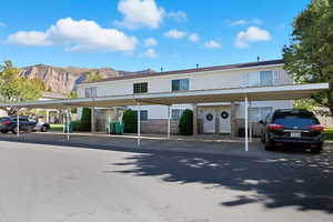 View of building exterior with a mountain view and covered parking