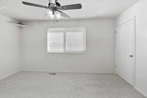 Unfurnished bedroom featuring carpet flooring, ceiling fan, and a textured ceiling