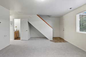 Basement with light colored carpet and baseboards