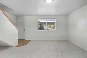 Spare room with light colored carpet and a textured ceiling