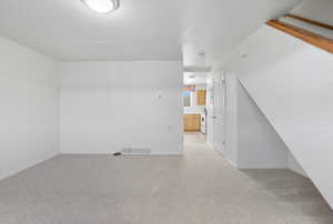 Bonus room featuring light carpet and a textured ceiling
