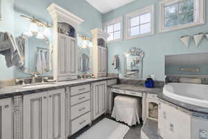 Bathroom featuring double vanity and a garden tub