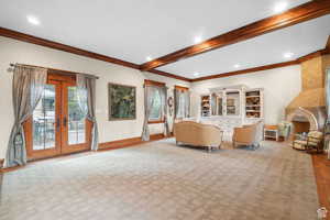 Living area featuring french doors, crown molding, beam ceiling, recessed lighting, and a fireplace