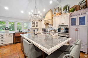 Kitchen featuring tasteful backsplash, stainless steel appliances, recessed lighting, lofted ceiling, and hanging light fixtures