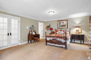 Carpeted bedroom featuring ornamental molding and french doors