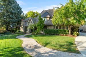 View of front of property with a front lawn, a chimney, and stucco siding