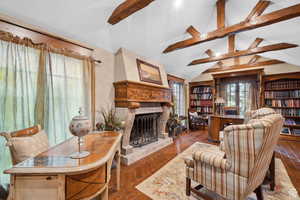 Living room featuring a fireplace with raised hearth and wood finished floors
